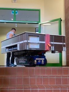Treppenraupe Hamburg im Einsatz – Treppenpanzer transportiert eine Klimaanlage sicher durch ein Treppenhaus.